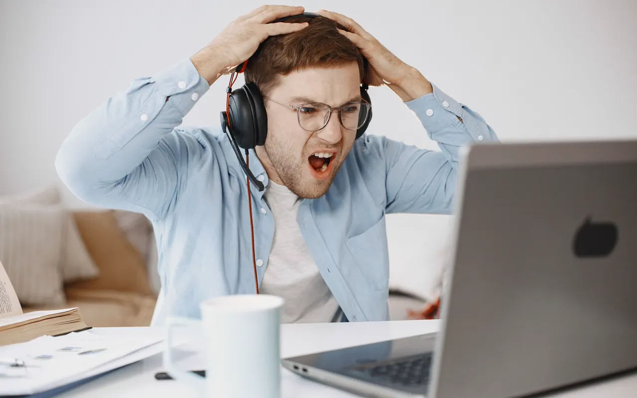 Persona preocupada frente a una computadora portátil que presenta un problema.